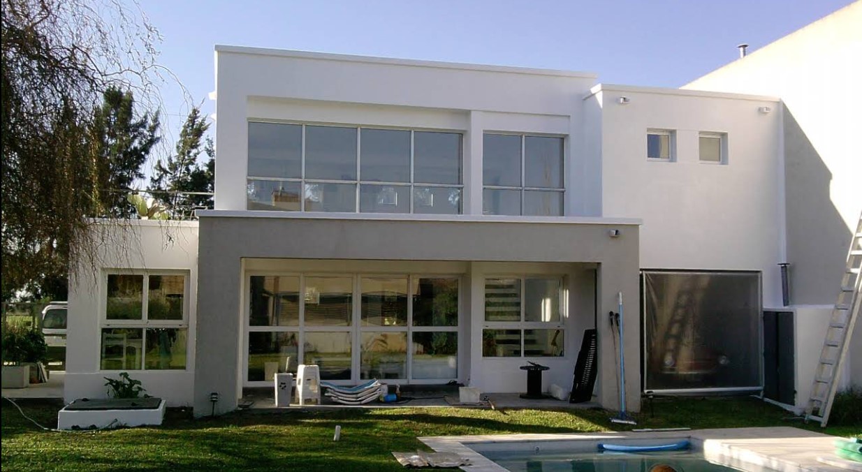 Vivienda de dos plantas con fachada blanca y ventanales